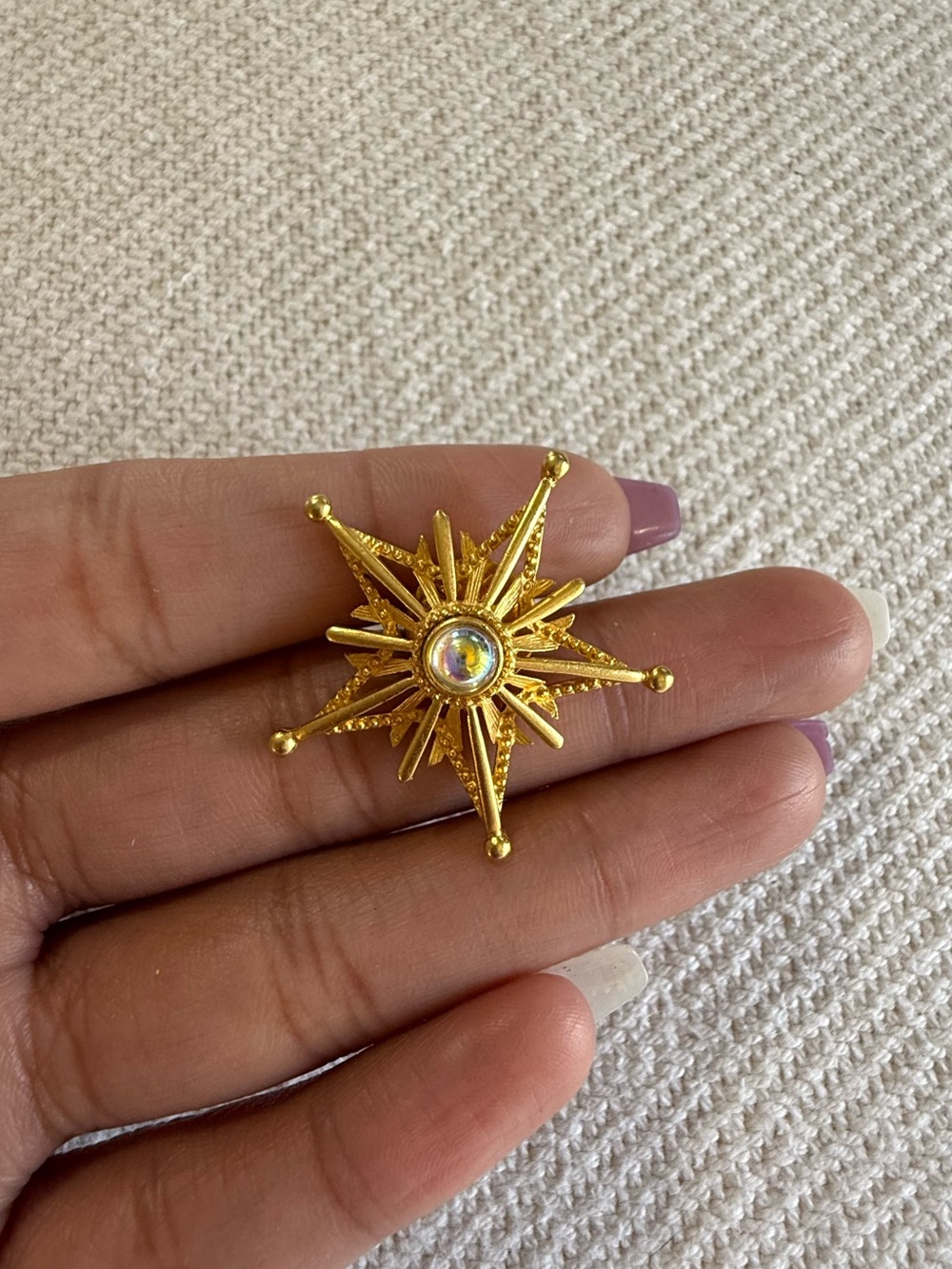 Mid-Century Modern vintage gold-tone atomic starburst lapel pin.